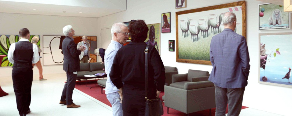 Menschen im ILB-Foyer die sich eine Kunstaustellung ansehen